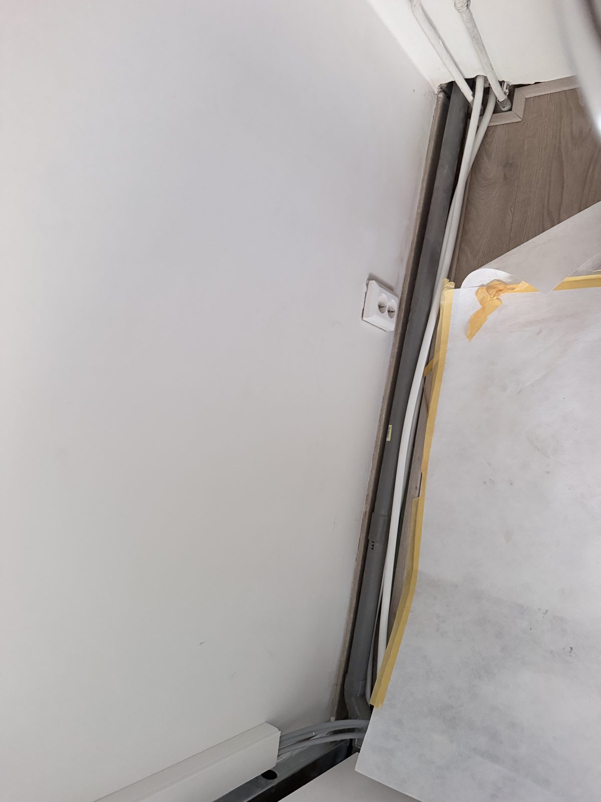 Leidingwerk laag op de wand, direct achter spoelbak en vaatwasser